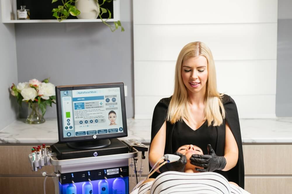 Specialist performing a Hydrafacial on a client at Youth Labs